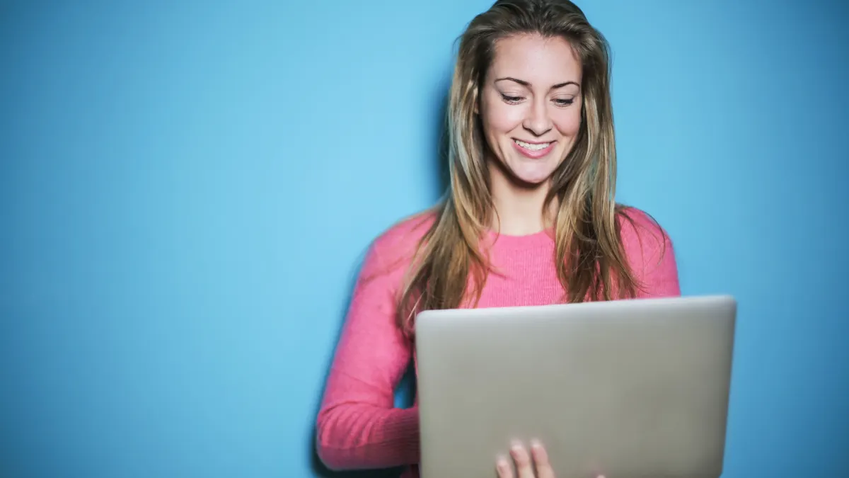 Ondernemer werkt op een laptop tegen een blauwe achtergrond